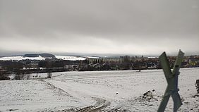 Eine weitläufige, schneebedeckte Landschaft.